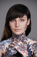 Image showing Woman, portrait and stylist with tattoo for body art, style or facial treatment on a gray studio background. Face of female person, young model or smile for design, creativity or cool beauty artist