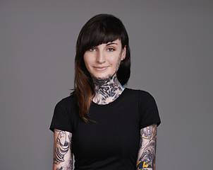Image showing Happy woman, portrait and tattoo with fashion for facial treatment, style or body art on a gray studio background. Female person, young model or smile for design, creativity or cool beauty artist