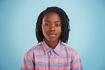 Image showing African teenager, face and fashion in studio with creative, style and confidence on a blue background. Portrait of young and cool model, student or boy in natural hair and casual or trendy clothes