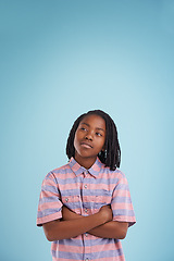 Image showing Boy, thinking or black child with arms crossed in studio for question, memory or reflection on blue background. Brainstorming, remember or African teen model with vision for solution, why or guess