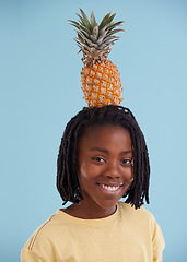 Image showing Portrait, smile and boy child with pineapple in studio for food, wellness or gut health on blue background, Fruit, balance and face of happy African teen model with organic diet, nutrition or detox