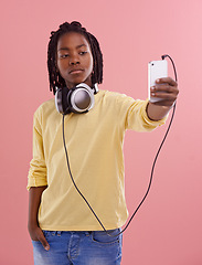 Image showing Teen, boy and selfie of student in studio with headphones for listening to music and post on social media. High school, kid and live streaming on blog with pride and confidence in profile picture
