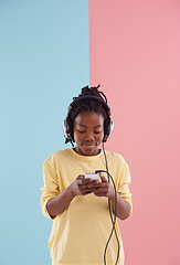 Image showing Teen, boy and relax with phone and headphones in studio for listening to music in high school and reading. Happy, kid and creative post on social media with audio and watch live stream on app