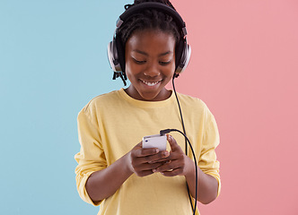 Image showing Teen, relax and boy with phone and headphones in studio for listening to music in high school and reading. Happy, kid and writing creative post on social media with audio or watch live stream on app