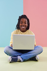 Image showing Teenager, portrait and laptop in studio for online education, e learning and creativity on the floor. Kid, student or African boy with computer for school in pastel color or blue and pink background