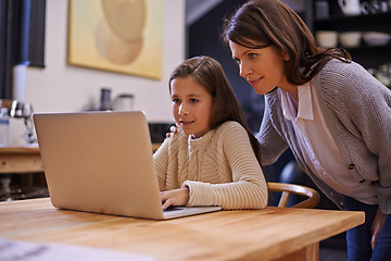 Image showing Mom, child and learning with laptop for support, care or browsing in the kitchen at home. Mother, daughter or kid typing on computer for social media, reading or helping girl on project or homework