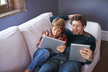 Image showing Father, son and tablet for gaming on couch together, technology and online streaming for bonding at home. Digital world, internet and man with boy child in living room, gamer app and entertainment