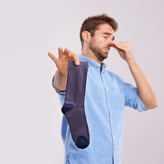 Image showing Man, smelly socks and close nose for poor hygiene with clothes, bad odor or stink with disgust isolated on white background. Unpleasant, dirty and foul with negative reaction for stench in studio