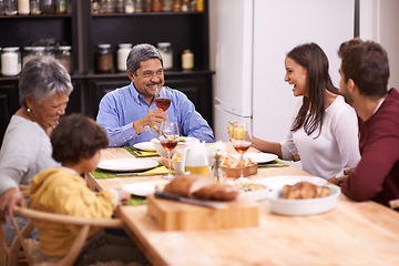 Image showing Happy, big family and food with wine at dinner table in thanksgiving, bonding or get together at home. Grandparents, parents and grandchild with smile in happiness for meal, feast or weekend at house