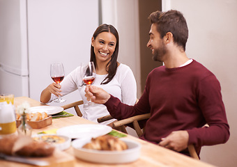 Image showing Cheers, dinner and smile with couple at table in dining room, food, and drinks for celebration in home. Toast, man and woman at lunch together with wine, fun and happiness, relax and holiday date