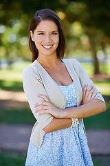 Image showing Happy woman, portrait and nature for outdoor fashion with travel, confidence and summer clothes. Young and casual person in floral dress with smile, holiday and arms crossed in a park or garden