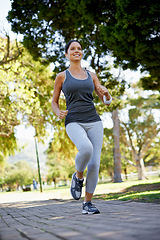 Image showing Happy woman, running or training with music in park, listening or streaming audio for exercise in nature. Athlete, smile face or wellness with headphones for fitness or runner in outdoor in montreal