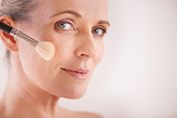 Image showing Brush, beauty and portrait of woman in studio for cosmetic, self care and facial glow routine. Makeup, foundation and mature person with cosmetology tool for treatment by white background with mockup