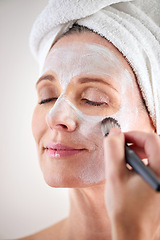 Image showing Beauty, mature woman and mask with brush in studio for skincare or anti aging on self care, wellness and fresh skin. Closeup, female person and glow with smile for facial and satisfied or luxury