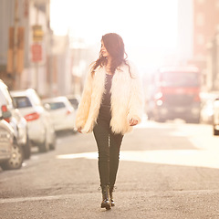 Image showing Woman, fashion and walk on confidence in street with winter or cold weather, street wear and downtown New York. Female person, style and trendy clothes or outfit for city trends and lens flare