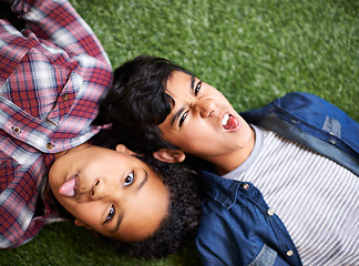 Image showing Siblings, girl and boy on grass, funny and portrait for smile, tongue out or relax in backyard at family home. Crazy children, brother and sister for care, comic or above on vacation, lawn and spring