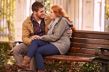 Image showing Couple, love and sitting with hug at park in cold weather or winter, together and smile in London. Relationship, commitment and bonding for romance with soulmate, care and happiness on holiday