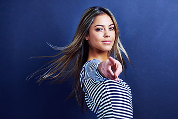 Image showing Portrait, woman and hand pointing at you in studio for attention, choice or selection on blue background. Face, smile and female model with finger vote for decision, calling or invitation gesture