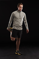 Image showing Man, legs and stretching training in studio for muscle mobility or exercise workout, flexibility or black background. Male person, earphones and wellness athlete for practice, streaming or mockup