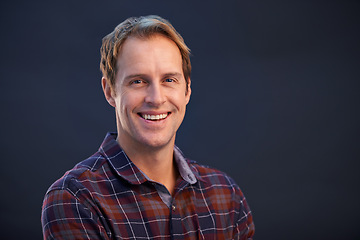 Image showing Happy, nerd and portrait of man in studio, dark background and smile with pride or confidence in fashion. Geek, face and person with plaid pattern on shirt or relax in casual style on mockup space