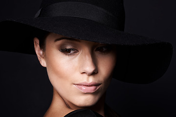 Image showing Woman, fashion and hat with mystery beauty on black background with makeup cosmetics, confidence or style. Female person, studio and model with mockup space in America with glamour, vintage or luxury