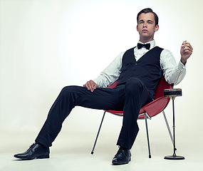 Image showing Fashion, gentleman and portrait with tuxedo and cigarette for stylish, trend and habit with suit and luxury. Young person and sit with confidence for vintage, wealthy and handsome for rich on mockup