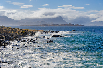 Image showing Majestic waves crashing onto rocky shoreline of a remote coast o