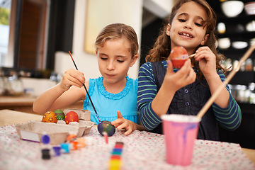Image showing Painting eggs, sisters and home with girls, smile and hobby with recreation and artistic with happiness. Easter, siblings or kids with child development or creative with tools or colour with activity