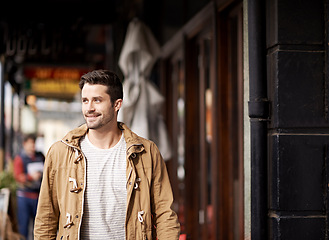 Image showing Man, face and happiness in city with fashion by restaurant with urban style, trendy outfit and confidence. Male person, smile and relax outdoor in town with walking, casual clothes and morning trip