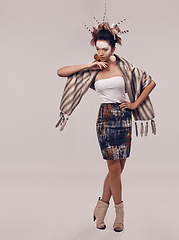 Image showing Model, dancer or culture headdress in studio with feathers, fashion and tribal make up in trendy clothes. Native american woman, creative and indigenous cosmetics and accessories on grey background