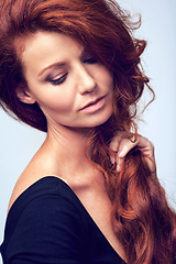 Image showing Beauty, relax and woman in studio with haircare, natural keratin glow and healthy hairstyle. Growth, shine and confident girl with red hair, wellness and luxury salon treatment on blue background