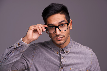 Image showing Young man, face and glasses in studio for eye care, vision and new frame with confidence on a gray background. Portrait of a young person or cool model in spectacles, eyewear and vision or lens check