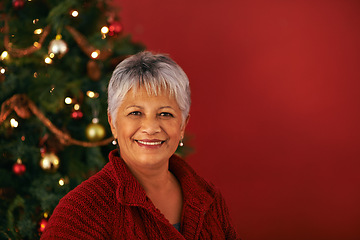 Image showing Christmas, smile and portrait of senior woman in studio for Christian holiday celebration by tree isolated on red background mockup space. Xmas, face or happy female person at festive party in Brazil