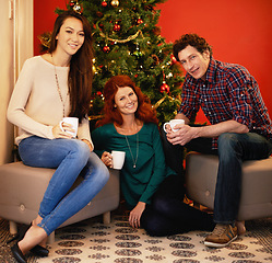 Image showing Friends, Christmas and coffee in home, tree with decor in living room for holiday with beverage. Hot chocolate, smile or people together, Christian celebration on Xmas eve and happy in winter season