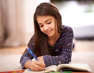 Image showing Girl, coloring book and drawing on floor for sketch in home with learning, development or lying in lounge. Kid, art and education for studying, creativity or relax on carpet at family house in Madrid