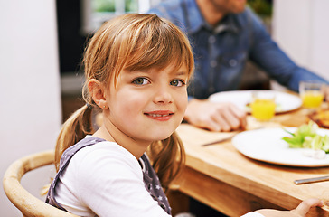 Image showing Girl, child and smile in portrait at dinner table for eating, food and relax on holiday in family house. Kid, happy and people in dining room for lunch with nutrition, diet and together in home