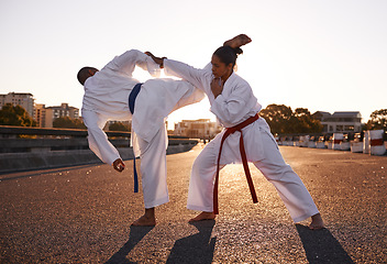 Image showing People, karate and fighting with personal trainer in city street for self defense, technique or style. Man and woman fighter or athlete in fitness training, martial arts or kick boxing in urban town