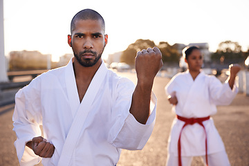 Image showing Serious people, karate and martial arts with personal trainer for self defense, class or teaching in city street. Man and woman fighter or athlete in fitness training, kata or technique in urban town