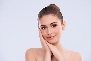 Image showing Beauty, cosmetics and portrait of happy woman with hands on face, smile and benefits of skincare in studio. Dermatology, health and girl with natural makeup, glow and skin care on white background