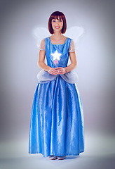 Image showing Woman, fairy godmother and smile in studio portrait with wand, wings and dress for magic by background. Person, fantasy and star with glow, shine and happy with power, wish and surreal fairytale