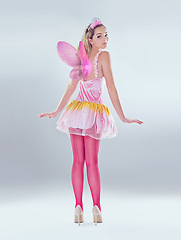 Image showing Woman, costume and fairy in studio on dress with wings as angel or butterfly for fantasy and creativity on white background. Back view, female person and princess style for halloween with glitter