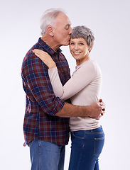 Image showing Portrait, kiss and senior couple on a white background for bonding, affection and happy relationship. Marriage, love and mature man and woman embrace for commitment, trust and care in studio together