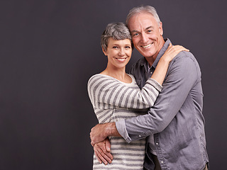 Image showing Portrait, hug and old couple with love, smile and relationship on a grey studio background. Retirement, happiness or senior man with mature woman or embrace with romance, marriage or bonding together