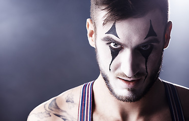 Image showing Face, man and mime for circus performance on dark background with light for stage, creativity and entertainment. Portrait, mime and performer with face paint or tattoo for show and creativity