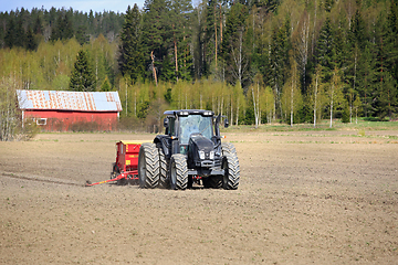 Image showing Valtra Tractor and Junkkari Seeder in Field