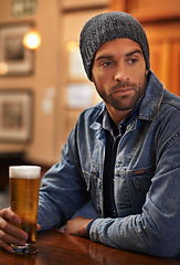 Image showing Beer, thinking and male person at pub for drinks, restaurant and entertainment for fun. Pensive, alcohol and cafe for thoughtful or social for relax, pub and beanie for cold weather in England