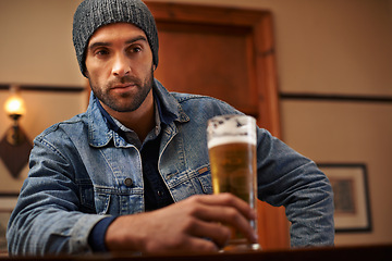 Image showing Beer, pub and male person thinking with alcohol, drinks and restaurant for entertainment. Pensive, lonely and bar for thoughtful or social for relax, night and beanie for cold weather in England