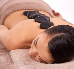 Image showing Wellness, hot stone and woman with back massage at spa for health, self care and grooming treatment in studio. Skin, calm and person with masseuse for warm rock body routine by white background.