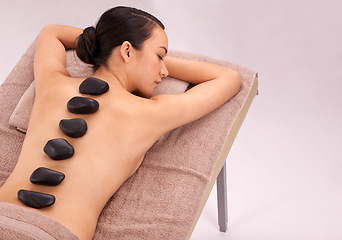 Image showing Spa, woman and massage with hot stone therapy and wellness with vacation and stress relief. Natural, person and girl with peace or calm with holiday and weekend break with skin detox or luxury resort