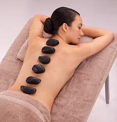 Image showing Peace, woman and massage with hot stone therapy and wellness with vacation, relax or rocks. Natural, person or girl with stress relief or calm with holiday or healing with skin detox or luxury resort